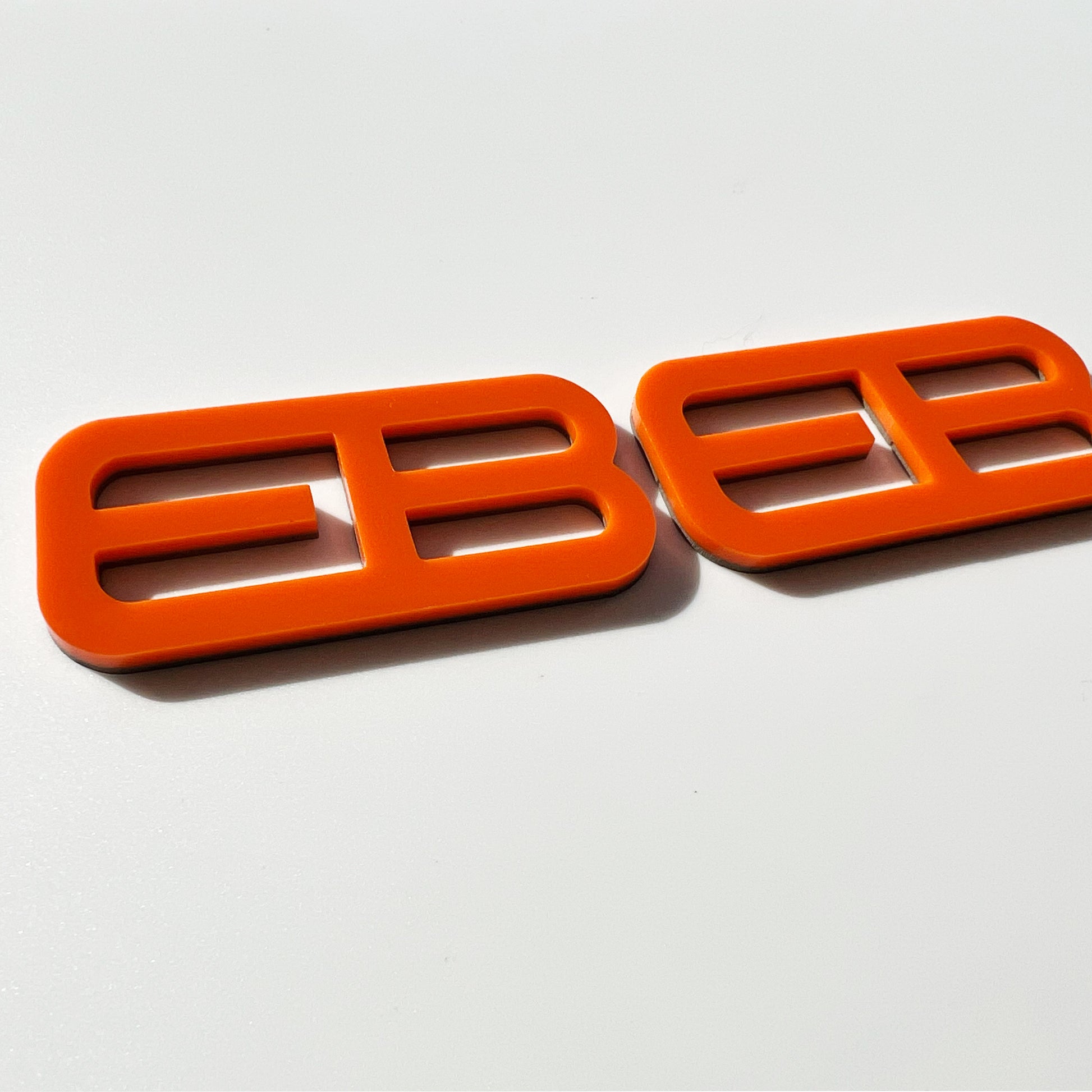 FMSgear bright orange custom emblems Ford Mustang f-150 with a sleek modern design on white background