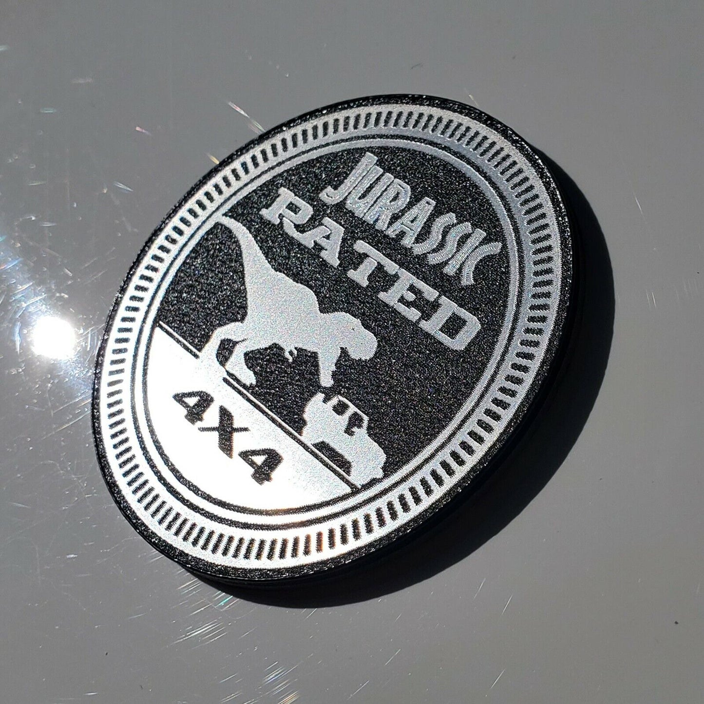 FMSgear Jurassic fender badge for jeep featuring a dinosaur and 4x4 design in silver and black