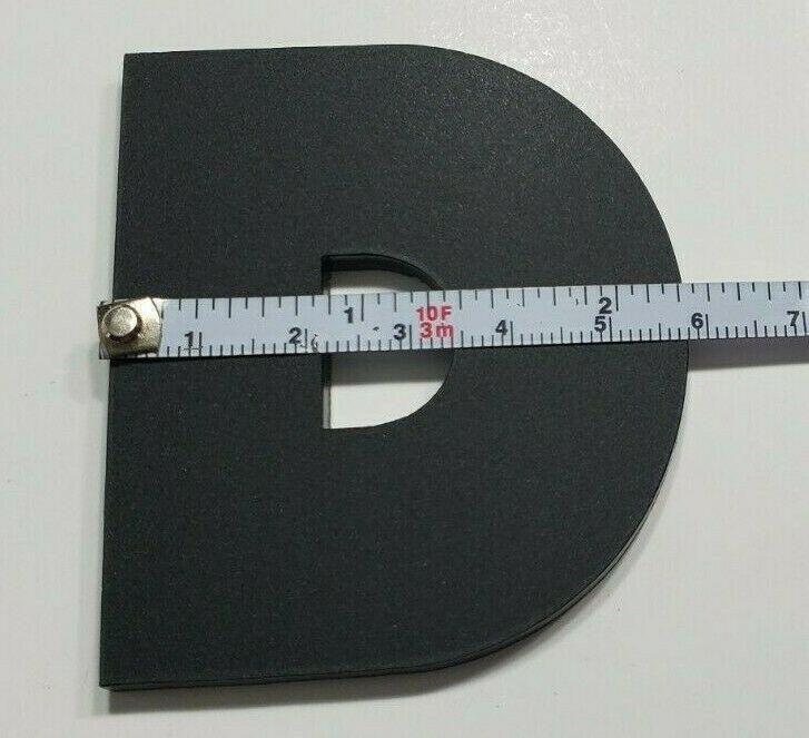 Black letter D molding piece with measuring tape showing size for custom diesel emblem Silverado