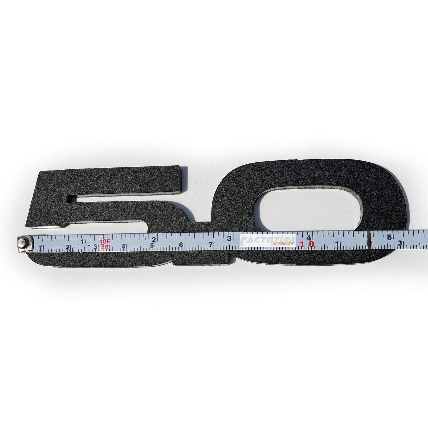 FMSgear custom Ford Mustang GT 5.0 emblems in black with textured finish and measuring tape for scale